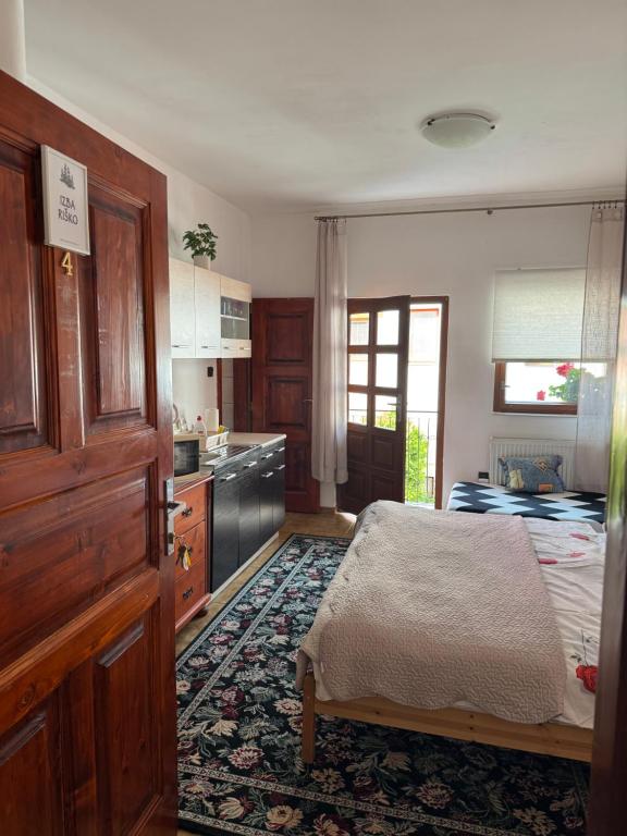 a kitchen with a bed and a table in a room at 2- posteľová izba s kúpeľňou a kuchynkou RIŠKO v PENZION TRSTENÁ in Trstená