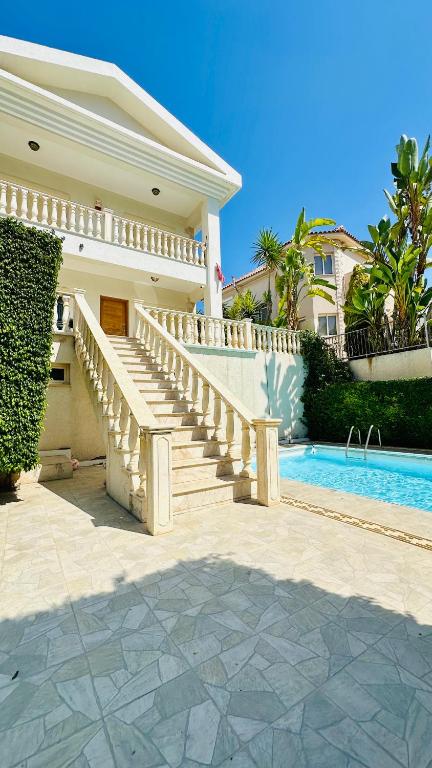 una casa con una escalera junto a una piscina en Alkeou Holiday Home, en Limassol