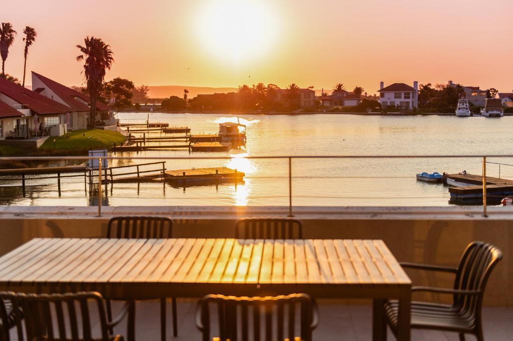 a table and chairs with the sunset in the water at Port Owen Marina Starlight 20 by First Private Stays in Velddrif