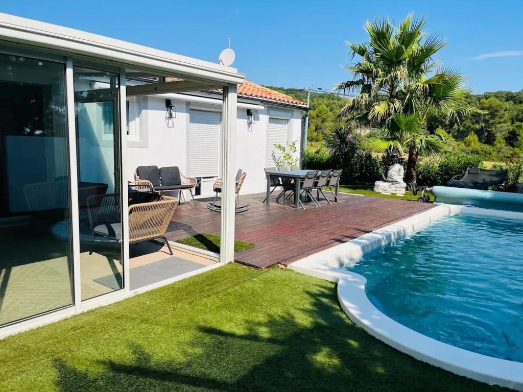 einen Hinterhof mit einer Terrasse und einem Pool in der Unterkunft Villa accueillante avec piscine à Saint-Paul-et-Valmalle in Saint-Paul-et-Valmalle