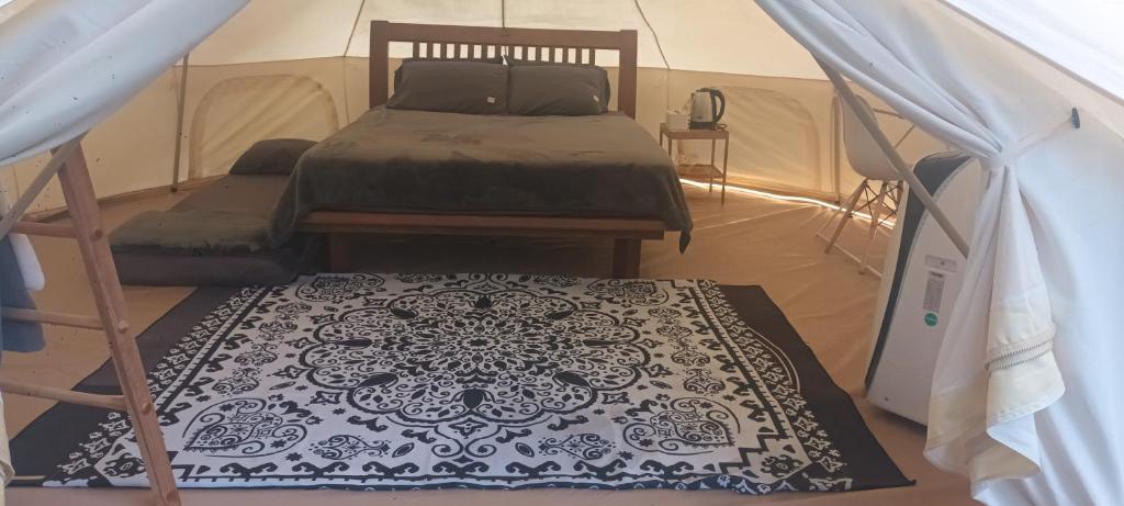 a bedroom with a bed and a rug in a tent at 5m Belle Tent for 4 people in Ban Huai Sok Noi