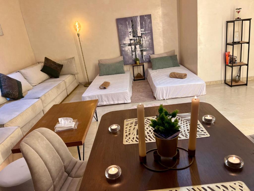 a living room with two beds and a table at Apartment Casa Marina - Borgone, Ocean & Hassan II Views in Casablanca