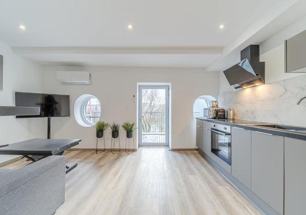 eine große Küche mit weißen Schränken und einem Tisch in der Unterkunft Rooftop d'exception, vue Rhône, 6 personnes, Caluire in Caluire-et-Cuire