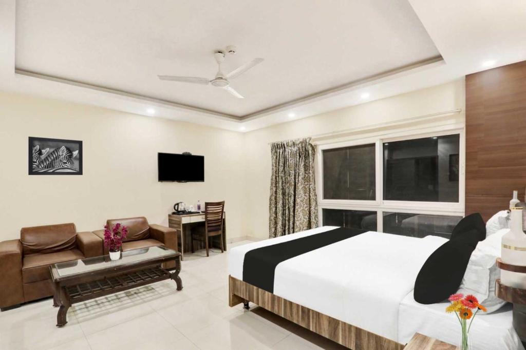a bedroom with a bed and a desk and a television at Palette Hotel and Resort Kankarbagh Main Road Formerly Aalcajars Inn in Bankipur