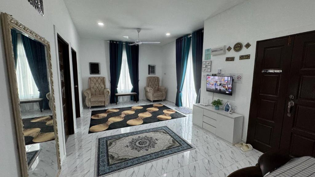 een woonkamer met een televisie en een kamer met een bank bij Mariamz Homestay near jetty Perhentian Island in Kampong Baru