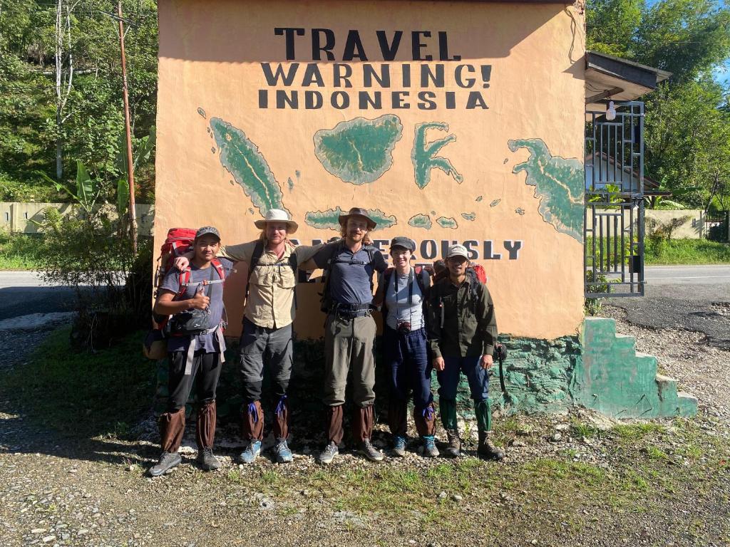 a group of people standing in front of a sign at Cinta alam inn in Lhokuenam