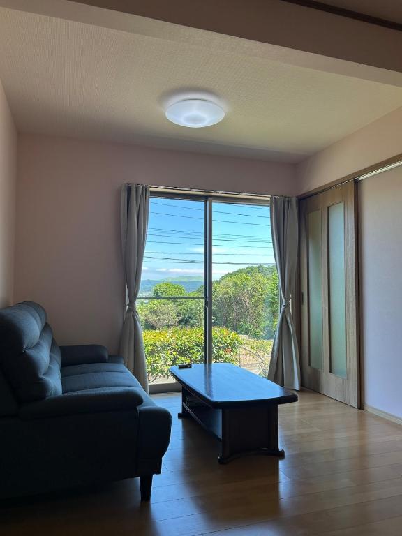 a living room with a couch and a table at アットホーム五島 in Goto