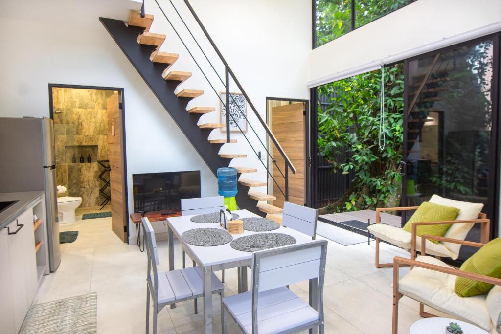 a living room with a table and chairs and a staircase at Somnara Bosque Tropical in Talamanca