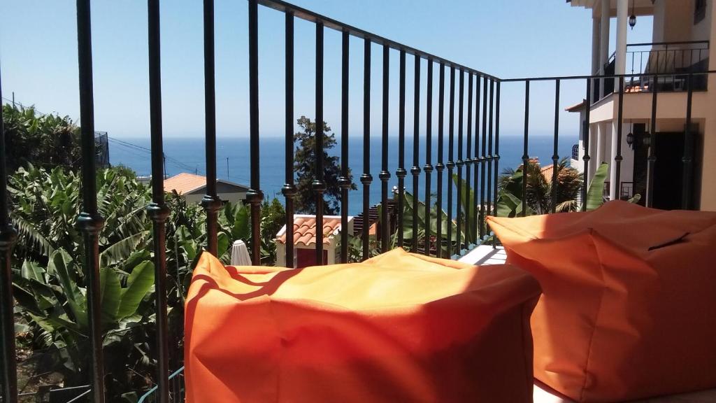 a balcony with an orange umbrella and a fence at Apart Monumental in Funchal