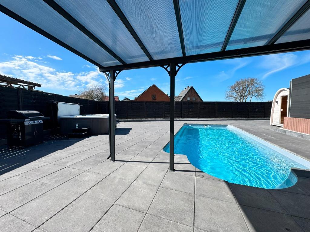 una piscina bajo un pabellón en un patio en Fewo Neubörger Wellness, en Neubörger