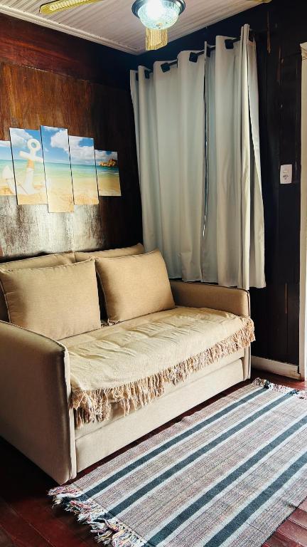 un lit assis dans une pièce avec un rideau dans l'établissement Casa mar, à Angra dos Reis