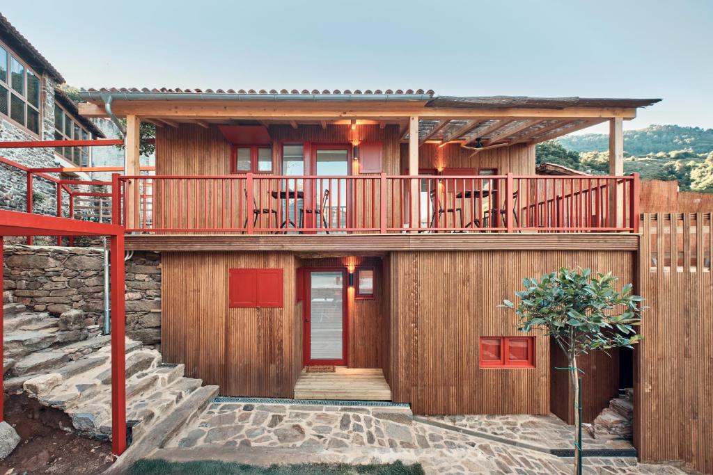 a wooden house with a deck and stairs at Pincelo Nature in Pincelo