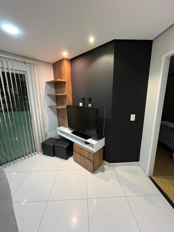 a living room with a flat screen tv on a wall at Flat shopping Ibituruna in Montes Claros