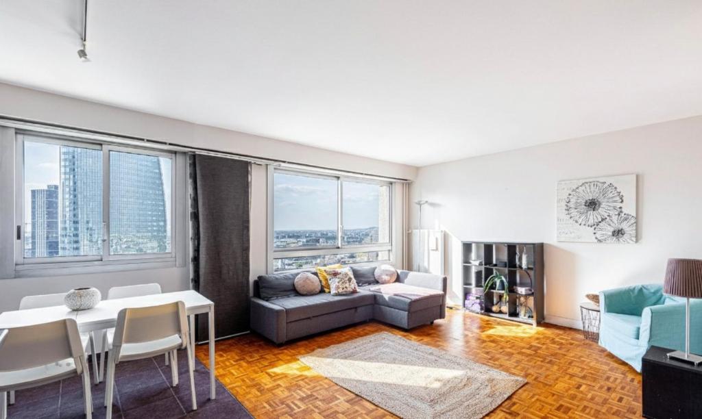 a living room with a couch and a table at GuestReady - Modern chic with a view in La Défense