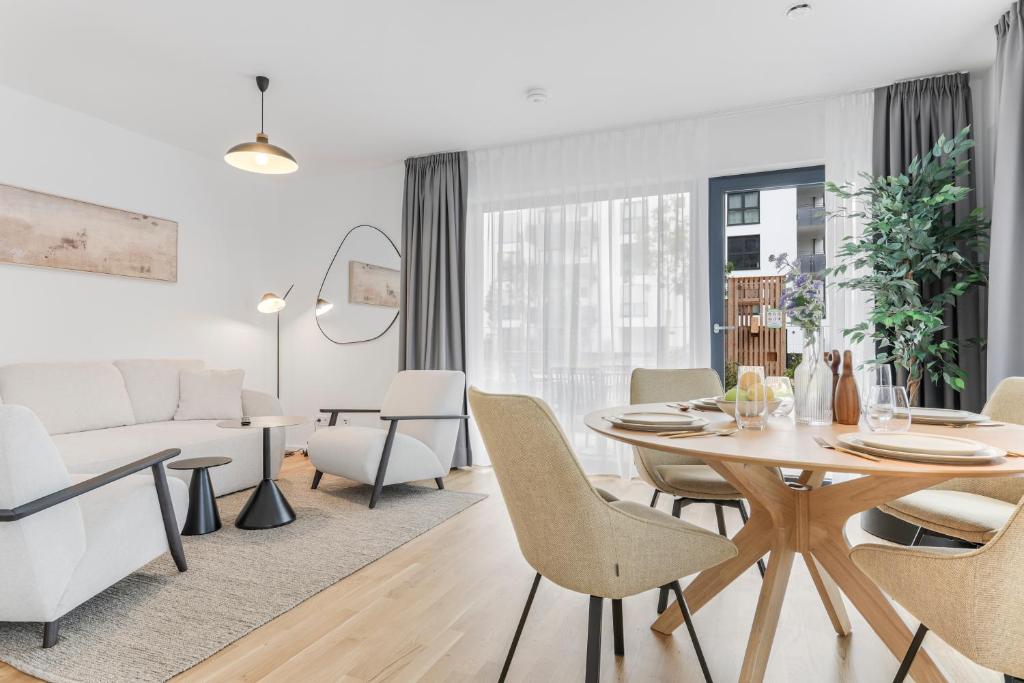 a dining room and living room with a table and chairs at cruwzo I Regensburg Towers - Design Apartments in Regensburg