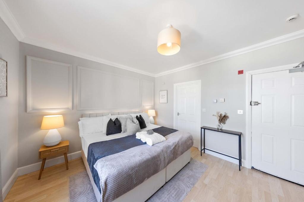 a bedroom with a large bed and a white door at Modern King Bed WiFi Kitchen Perfect for Long Stay in Gravesend