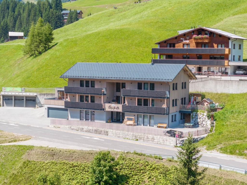 a house on a hill next to a road at Elisabeth Appartements in Damuls