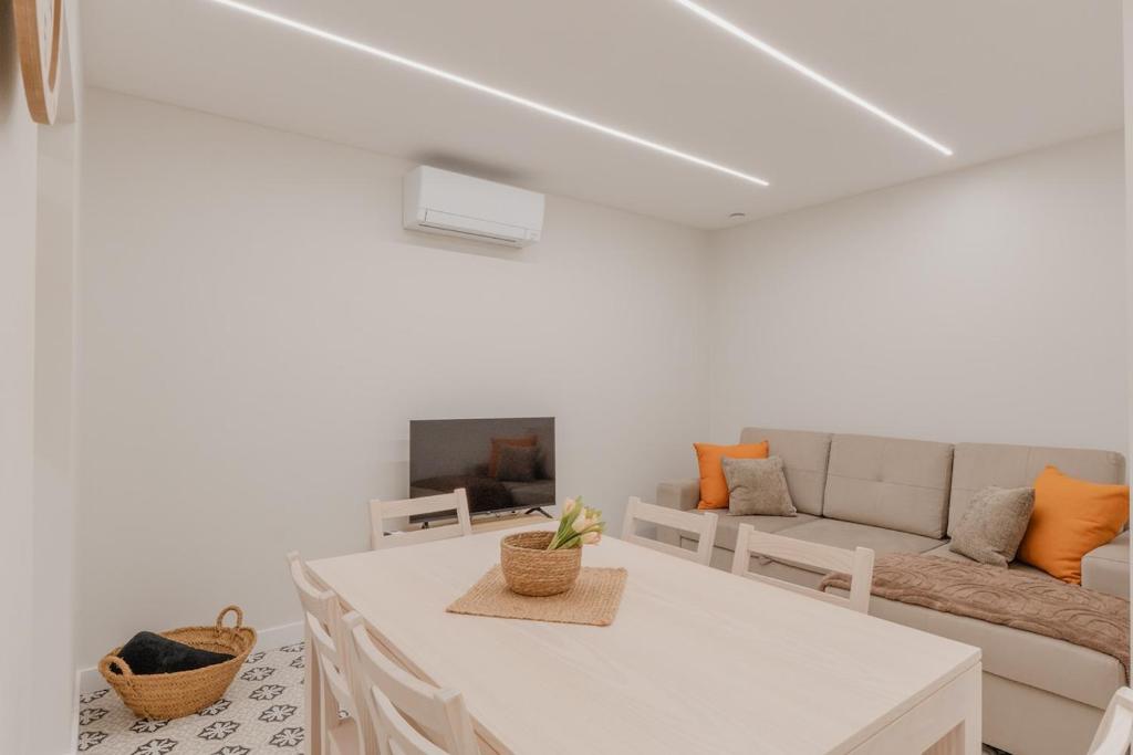 a white living room with a couch and a table at Newest cozy apartment B in Lisbon