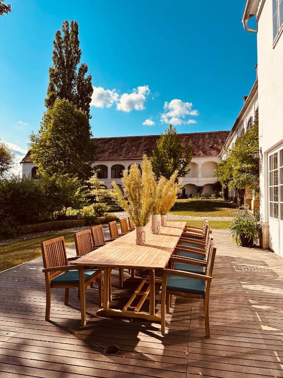 a wooden table and chairs on a patio at Schloss Welsdorf in Fürstenfeld