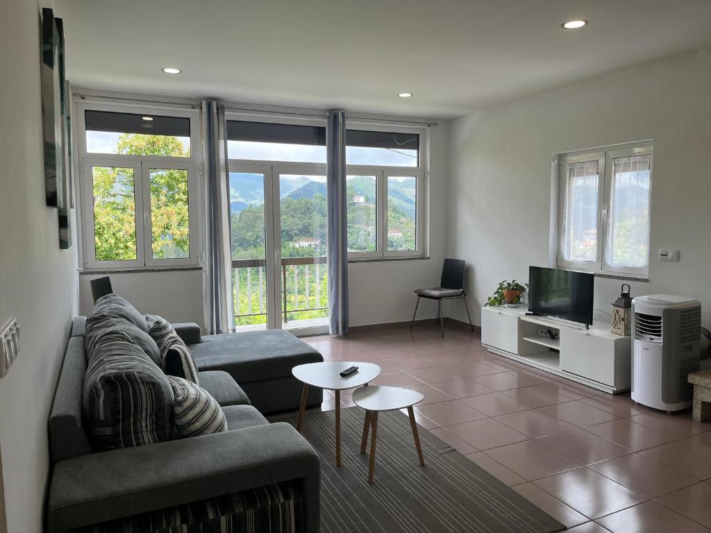 a living room with a couch and a tv at Casa De Casarelhos in Cova
