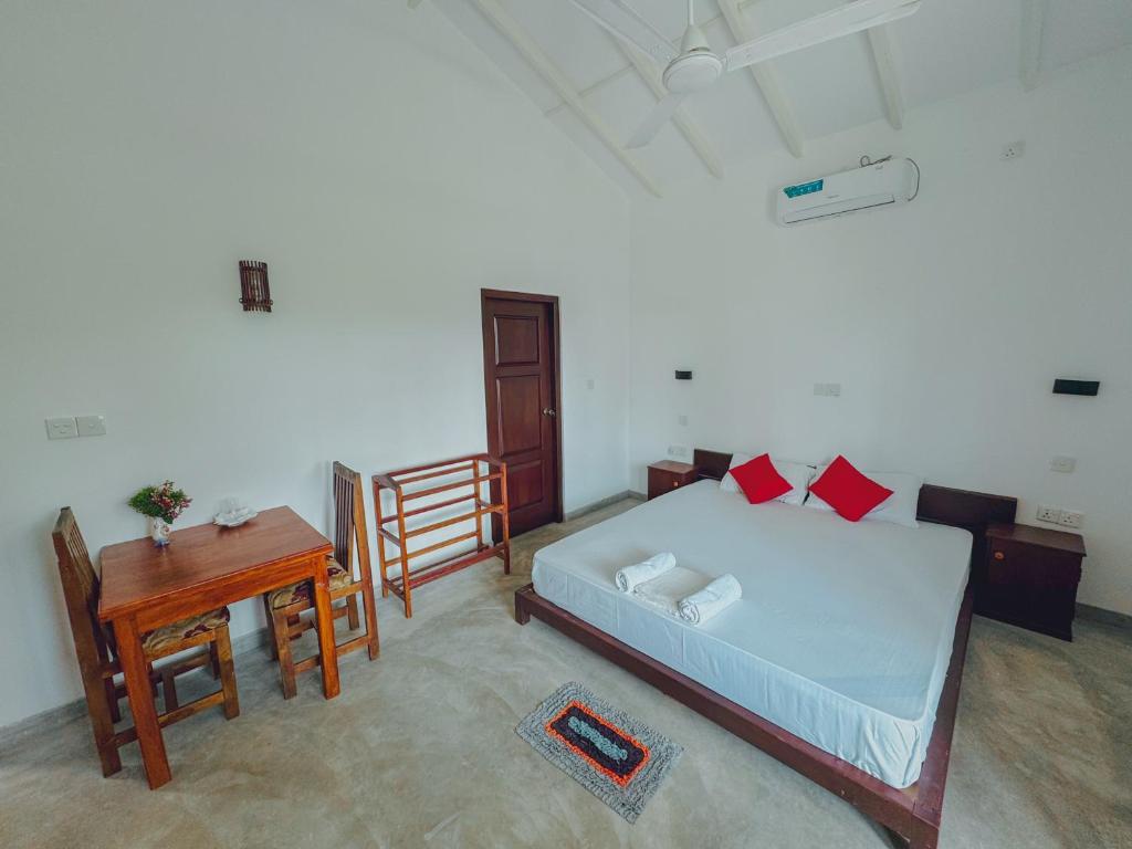 a bedroom with a bed and a wooden table at Sayuru Villa in Hikkaduwa