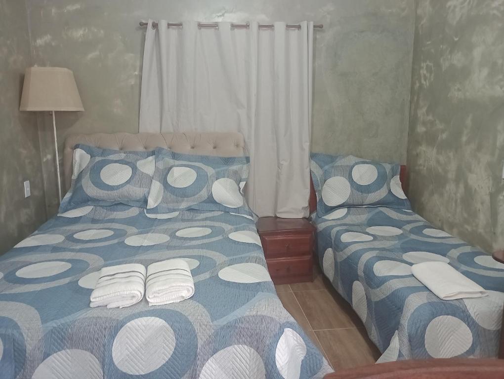 a bedroom with two beds with blue and white sheets at Recanto das Videiras in Maria da Fé