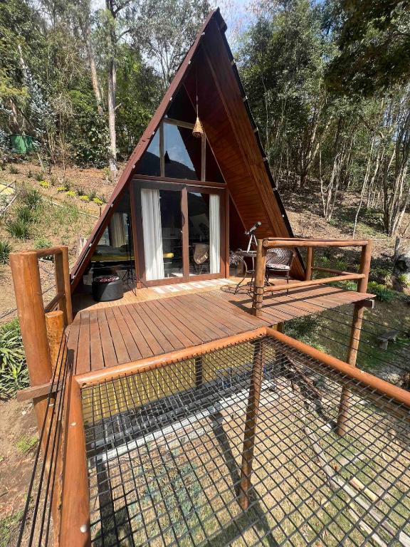 a small house with a wooden deck with a window at Chalé Águia in Petrópolis