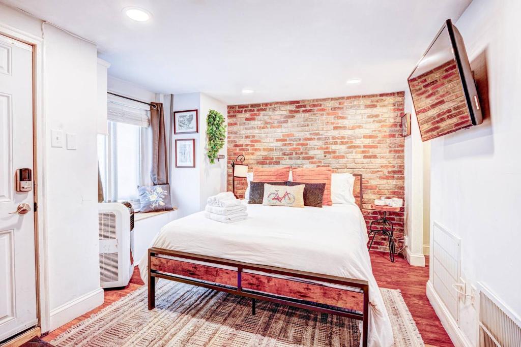 a bedroom with a bed and a brick wall at Eagle's Landing - Logan Airport in Boston