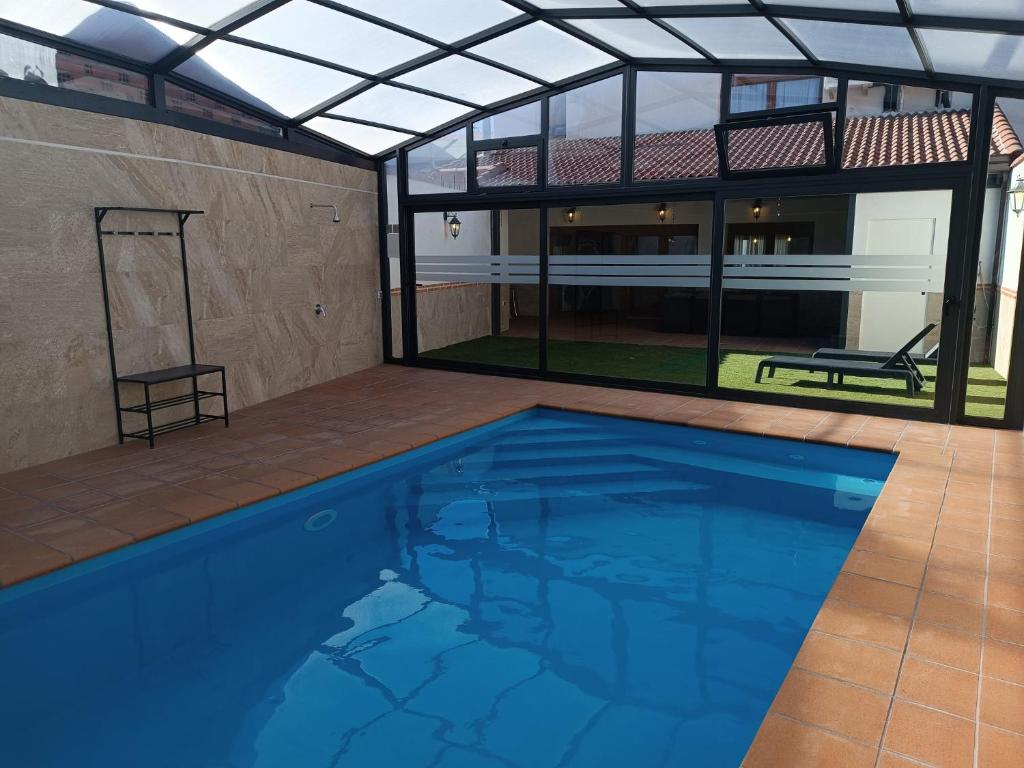 a swimming pool in a house with a glass roof at La Tinaja casa rural in Hernansancho