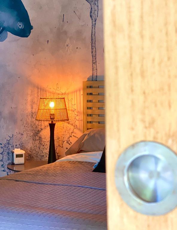 a bedroom with a bed and a lamp with a shark on the wall at Le Grand Bain in Marciac