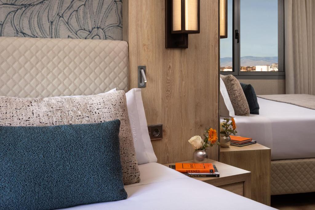 una camera con letto e cuscino blu di VP SOGNIO Metropolitano a Madrid