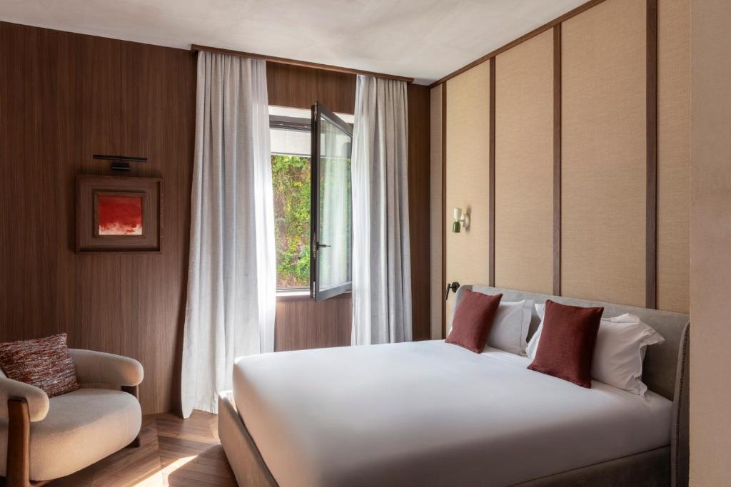 a bedroom with a white bed and a window at NAMAN HOTELLERIE - Condotti in Rome
