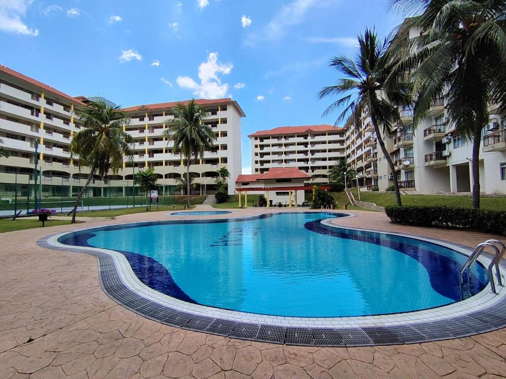 a swimming pool in front of some buildings at Iris 2 Bedroom Pool View Balcony in Kampong Tanah Merah