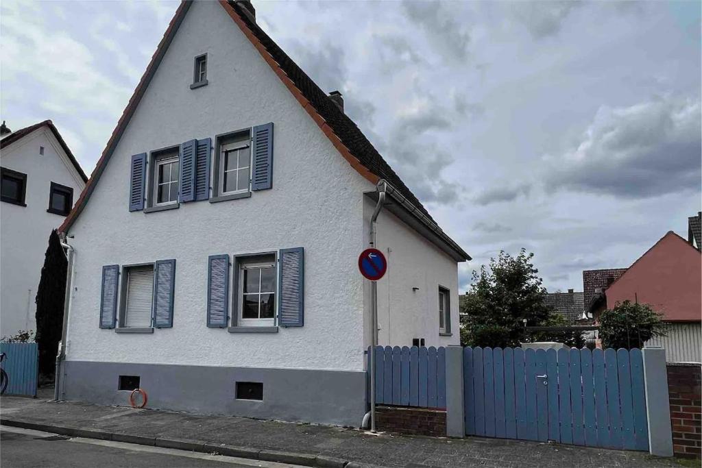 a white house with blue shuttered windows and a blue fence at Freistehendes Haus mit grossem Garten zur alleinigen Nutzung in Großkrotzenburg