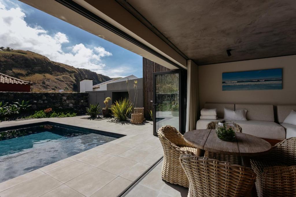 a patio with a table and chairs and a pool at Porta Celeste in Mosteiros