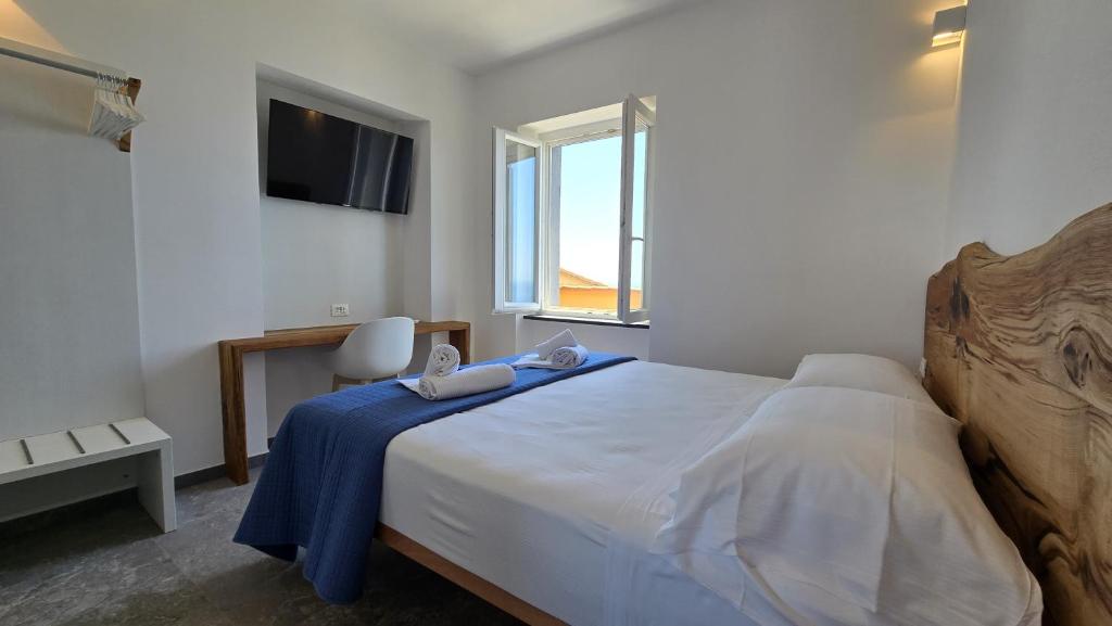 a bedroom with a large bed with a blue blanket at LA PIAZZETTA - Homy 5 Terre in Volastra