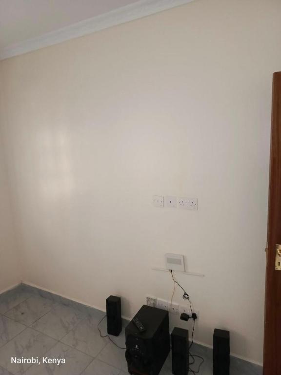 a room with a white wall with speakers at Colokhaly Apartment in Nairobi