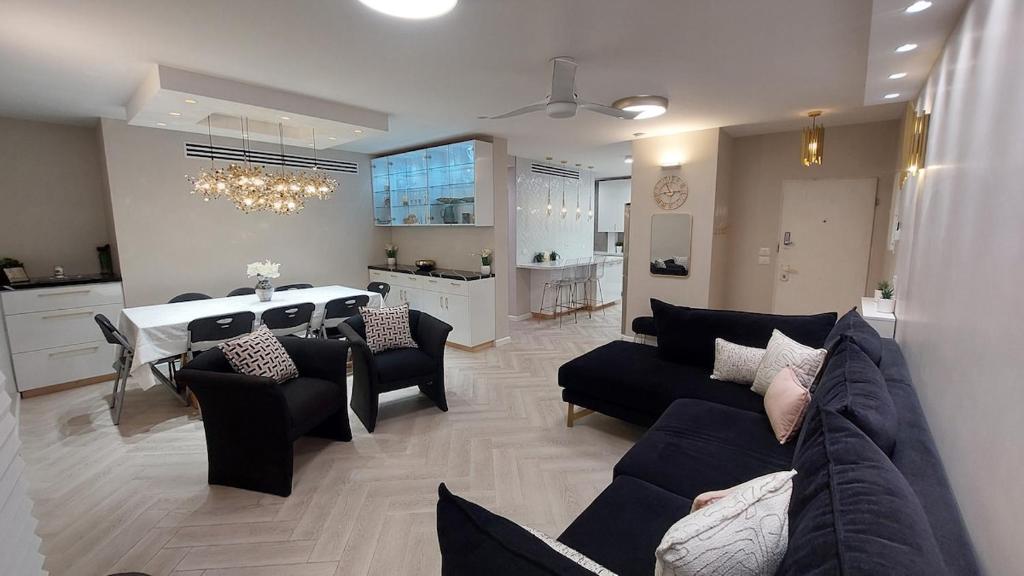 un salon avec un canapé et une salle à manger dans l'établissement Luxe on Dolev, à Bet Shemesh