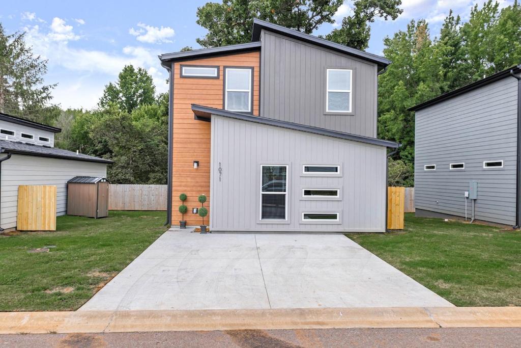 a house with a garage and a driveway at Modern 3BR Centerton Near Walmart HQ & Bentonville in Bentonville