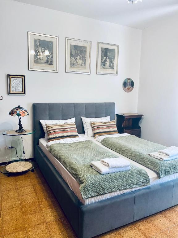 a bedroom with a blue bed with two pillows at San Dona Homely House in San Donà di Piave