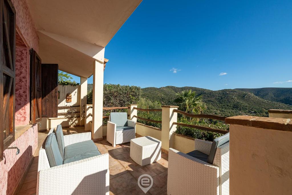 un balcon avec des chaises et une vue sur les montagnes dans l'établissement Aqua Vista Escape, à Marongiu
