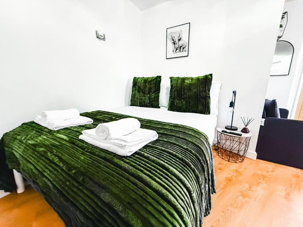 プジーにあるChic Studio, Free parking, Sleeps 2のベッドルーム1室(大型ベッド1台、緑のシーツ、タオル付)