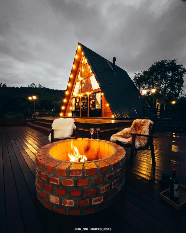a house with a fire pit in front of it at Cabana Flor do Sol in Luzerna