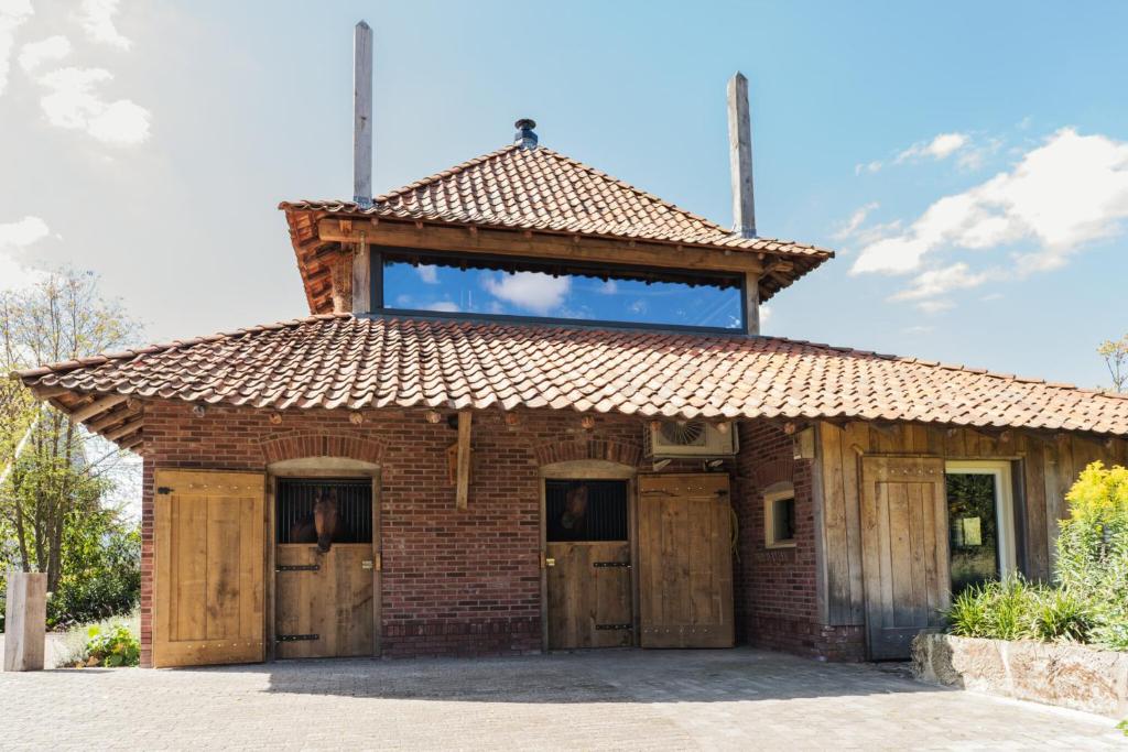 an old brick building with a roof on top at Landgoed Boneman in Meddoo