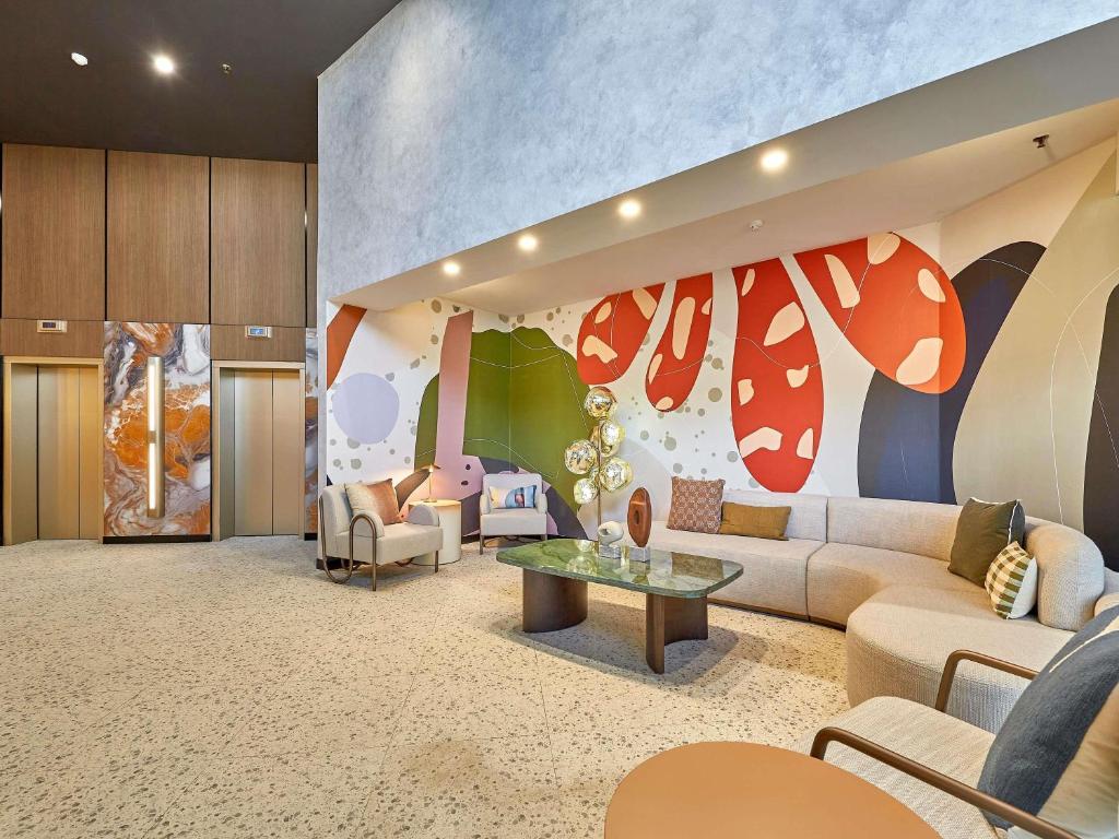 a living room with a couch and a table at ibis Perth in Perth