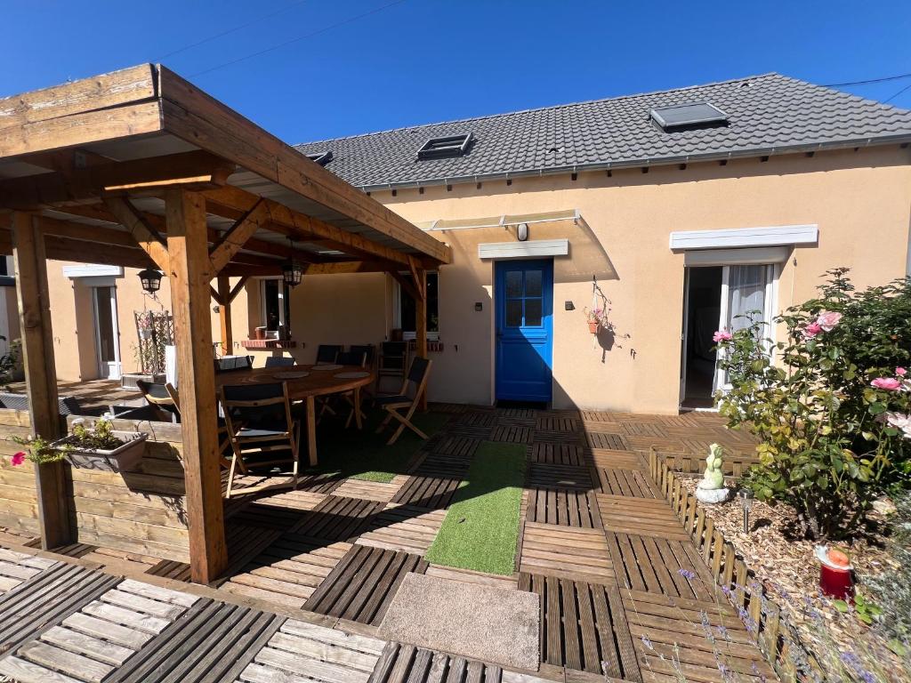 a wooden patio with a table and a wooden pergola at L'étape Giennoise in Gien
