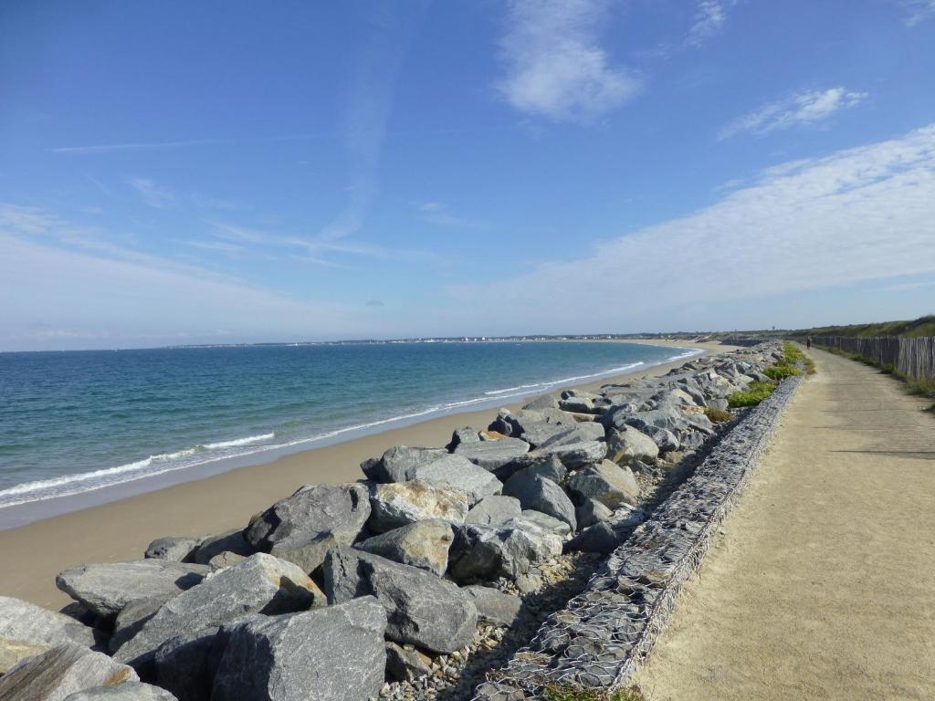 a beach with large rocks and the ocean at Tikazla - Séjour détente in La Turballe