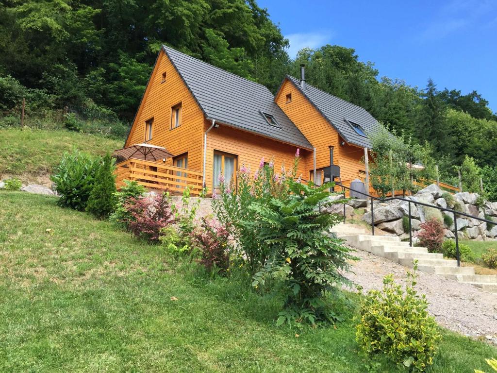 Cabaña de madera en un campo con árboles en Le Chalet La Cigogne et Le Chamois, en Munster