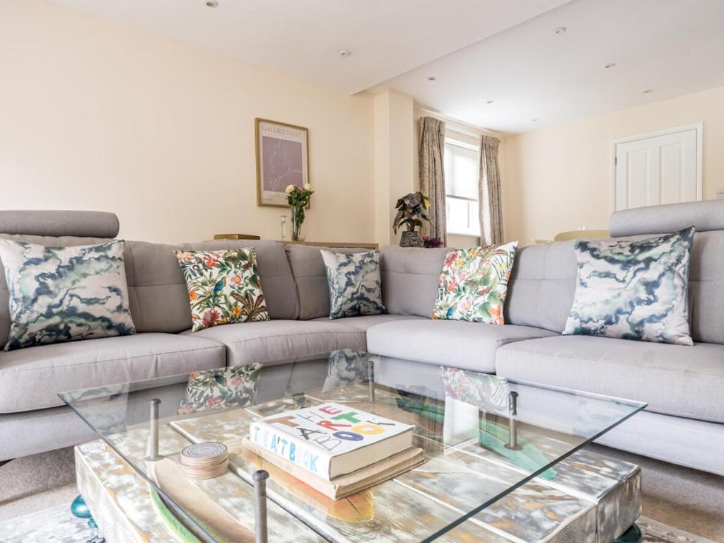 a living room with a couch and a glass table at Pass the Keys Spacious family home in Surrey in Addlestone
