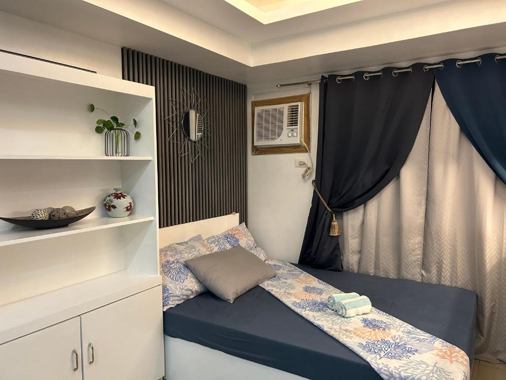 a small bedroom with a bed and a window at Avida tower 1 L21 staycation condotel rm1002 in Iloilo City